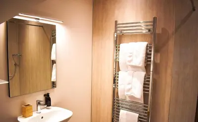 a bathroom with a sink and a mirror and towels at Orchy Bank House in Dalmally