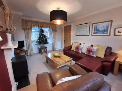 a living room with a couch and a table at Andreu Cottage in Callander