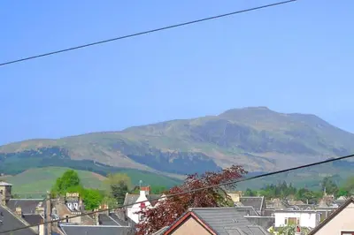 a view of a town with mountains in the background at Andreu Cottage in Callander