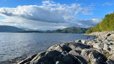 a large body of water with mountains in the background at The Heronry Hideaway with luxury hot tub in Ballachulish