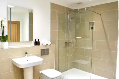 a bathroom with a shower and a toilet and a sink at The Heronry Hideaway with luxury hot tub in Ballachulish
