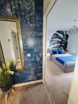 a bedroom with a mirror and a bed in it at Stylish 2 bedroom Apartment / FREE Gated Parking in Glasgow