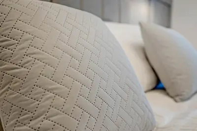 a white pillow sitting on a bed with two pillows at Pitcorthie House in Dunfermline