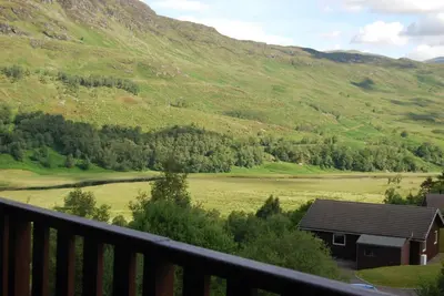 a view of a valley from a balcony at Ghillies Lodge Crianlarich in Crianlarich