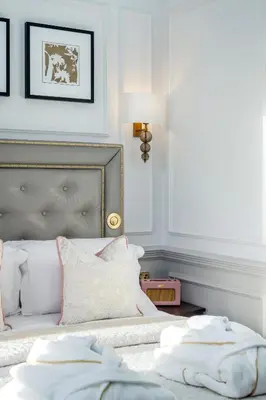 a bedroom with a bed with white sheets and a lamp at RÌGH Residences - George Street in Edinburgh