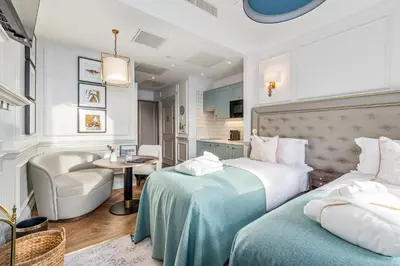 a hotel room with two beds and a chair at RÌGH Residences - George Street in Edinburgh