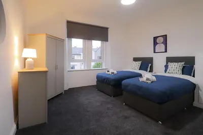 a hotel room with two beds and a window at Troon Golf Apartment in Troon