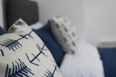 a close up of two pillows on a bed at Troon Golf Apartment in Troon