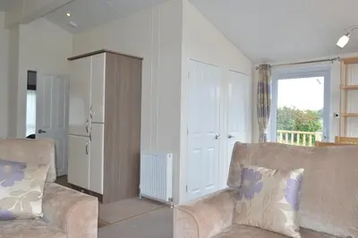 a living room with a couch and a cabinet at Sunnybrae, Isle of Luing in Cullipool