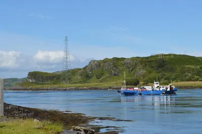 two boats in a river with a hill in the background at Sunnybrae, Isle of Luing in Cullipool