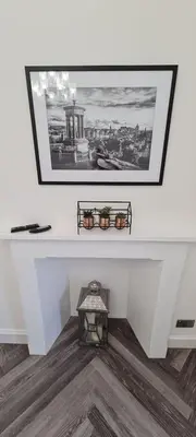 a white wall with a picture and two plants on it at Castle Terrace 1 Bed Apartment Looking onto Edinburgh Castle - Sleeps upto 4 in Edinburgh