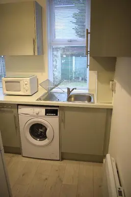 a kitchen with a washing machine and a sink at Kelpies Serviced Apartments- Robertson in Falkirk