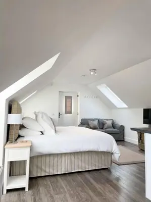 a white bedroom with a bed and a couch at Cosy Country Modern Studio with Patio Space. in Crieff