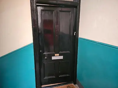 a black door in the corner of a room at Snug - Abhainn Apartment in Helensburgh