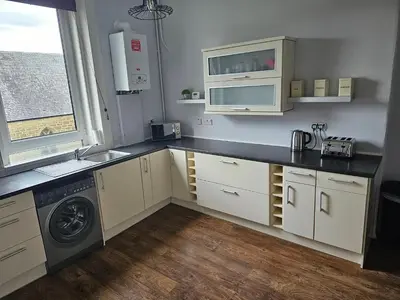 a kitchen with a sink and a washing machine at Snug - Abhainn Apartment in Helensburgh