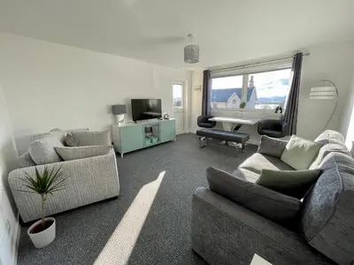 a living room with two couches and a desk at Dalriach Apartment in Oban