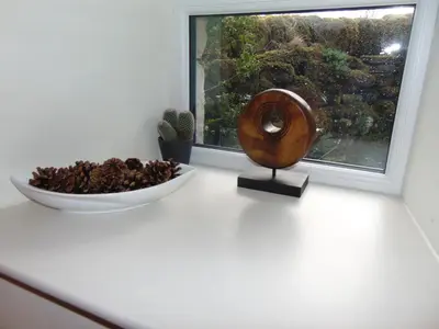 a bowl of pine cones and a bowl of nuts next to a window at Dreamwood Cottage, Loch Lomond, Luxury Apartment. in Glasgow