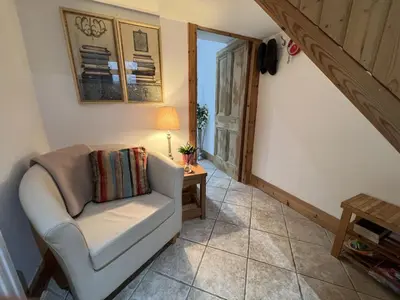 a living room with a chair and a table at Hollybank Cottage in Lochgoilhead