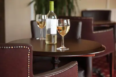a table with two wine glasses and a bottle of wine at SGE Esplanade Hotel in Dunoon