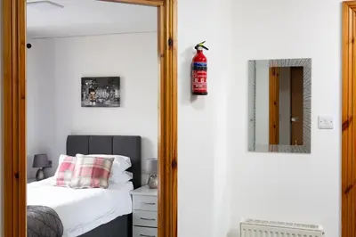 a bedroom with a mirror next to a bed at Bothwell Court Apartments in Dunfermline