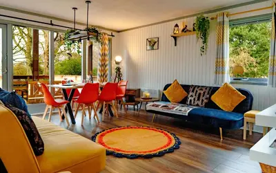 a living room with a couch and a table and chairs at Luxurious mountain retreat lodge Hunters Quay in Dunoon