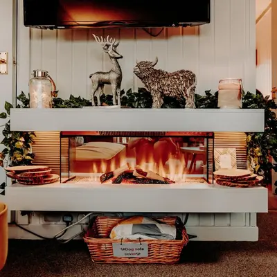 a fireplace with two deer statues on top of it at Luxurious mountain retreat lodge Hunters Quay in Dunoon