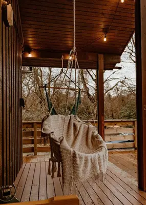a hammock on a porch with a wooden deck at Luxurious mountain retreat lodge Hunters Quay in Dunoon