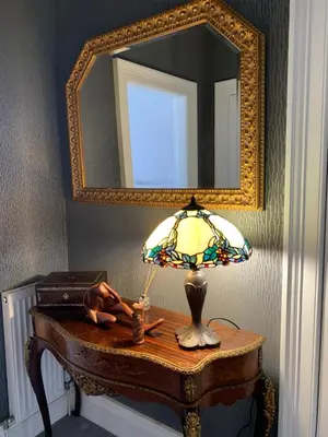 a lamp on a table in a room with a mirror at Seaview one bedroom apartment in centre of Largs in Largs