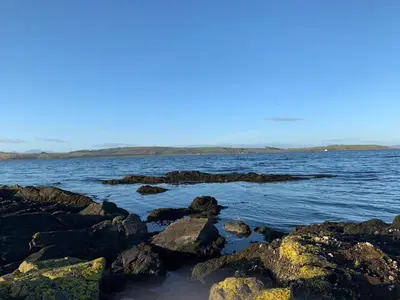 a body of water with rocks in the water at Seaview one bedroom apartment in centre of Largs in Largs