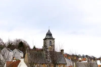 a building with a clock tower in a town at Stunning & unique apt in Culross in Culross
