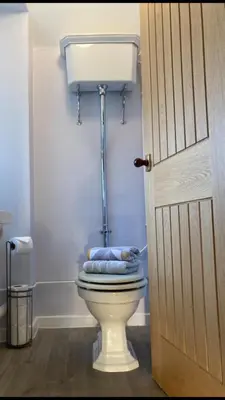 a bathroom with a toilet with blue towels on it at Menstrie Castle Stay in Stirling