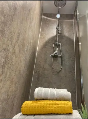 a bathroom with a shower with a bunch of towels at Menstrie Castle Stay in Stirling