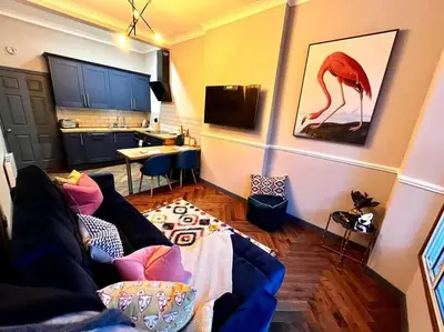 a living room with a couch and a kitchen at Stunning 1 bed Apt in West End in Glasgow