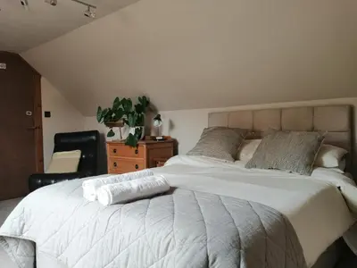 a bedroom with a large white bed and a chair at Nest Holiday Home Central Callander, Trossachs Self-catering in Callander
