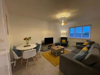 a living room with a couch and a table at 2 bedroom luxury flat in quiet village of Bishopton in Bishopton