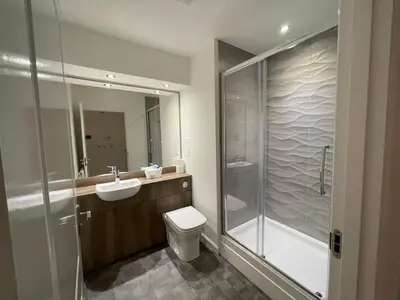 a bathroom with a toilet and a sink and a shower at 2 bedroom luxury flat in quiet village of Bishopton in Bishopton