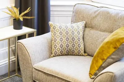 a couch with a pillow on it in a living room at Cross Road Apartment in Paisley