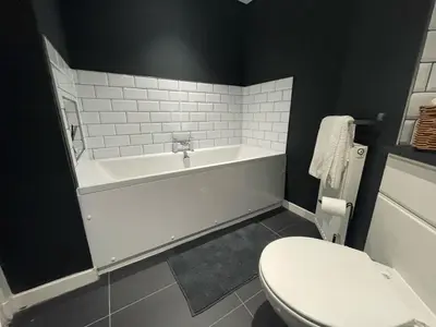 a bathroom with a white tub and a toilet at Niche View in Irvine