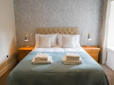 a bedroom with a bed with two towels on it at Stunning Edinburgh 1820s stables converted studio in Edinburgh