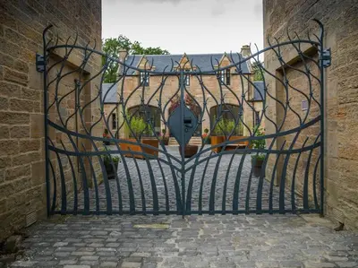 an open gate to a house with potted plants at Stunning Edinburgh 1820s stables converted studio in Edinburgh