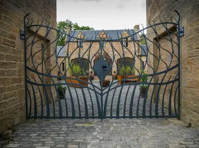 an open gate to a house with potted plants at Stunning Edinburgh 1820s stables converted house in Ratho