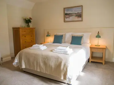 a bedroom with a large white bed with two pillows at Stunning Edinburgh 1820s stables converted house in Ratho