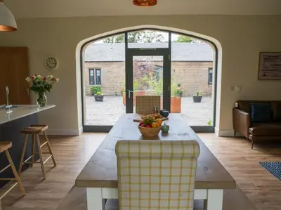 a living room with a table with a bowl of fruit on it at Stunning Edinburgh 1820s stables converted house in Ratho
