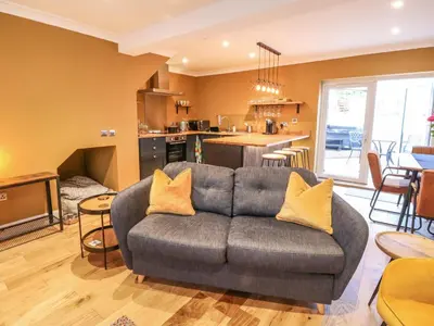 a living room with a couch and a kitchen at Feus Holiday Cottage in Auchterarder