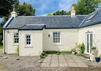 a small white house with a pathway in front of it at Kevington Cottage in Hunters Quay