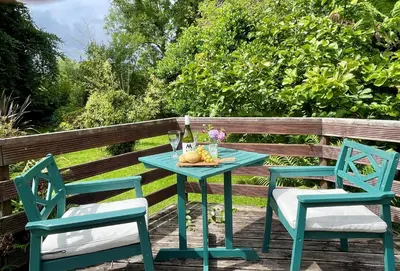 a blue table and two chairs on a deck at Kevington Cottage in Hunters Quay