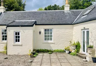 a white cottage with a pathway in front of it at Kevington Cottage in Hunters Quay