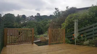 a wooden deck with two gates and a garden at Machrie Cottage, Oban, in Oban