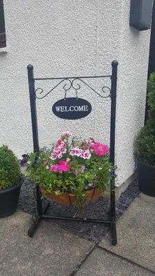 a sign with a pot of flowers in front of a building at Machrie Cottage, Oban, in Oban