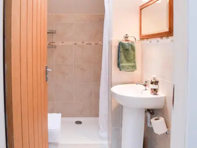 a bathroom with a sink and a shower at Puddingstone Cottage in Gartmore